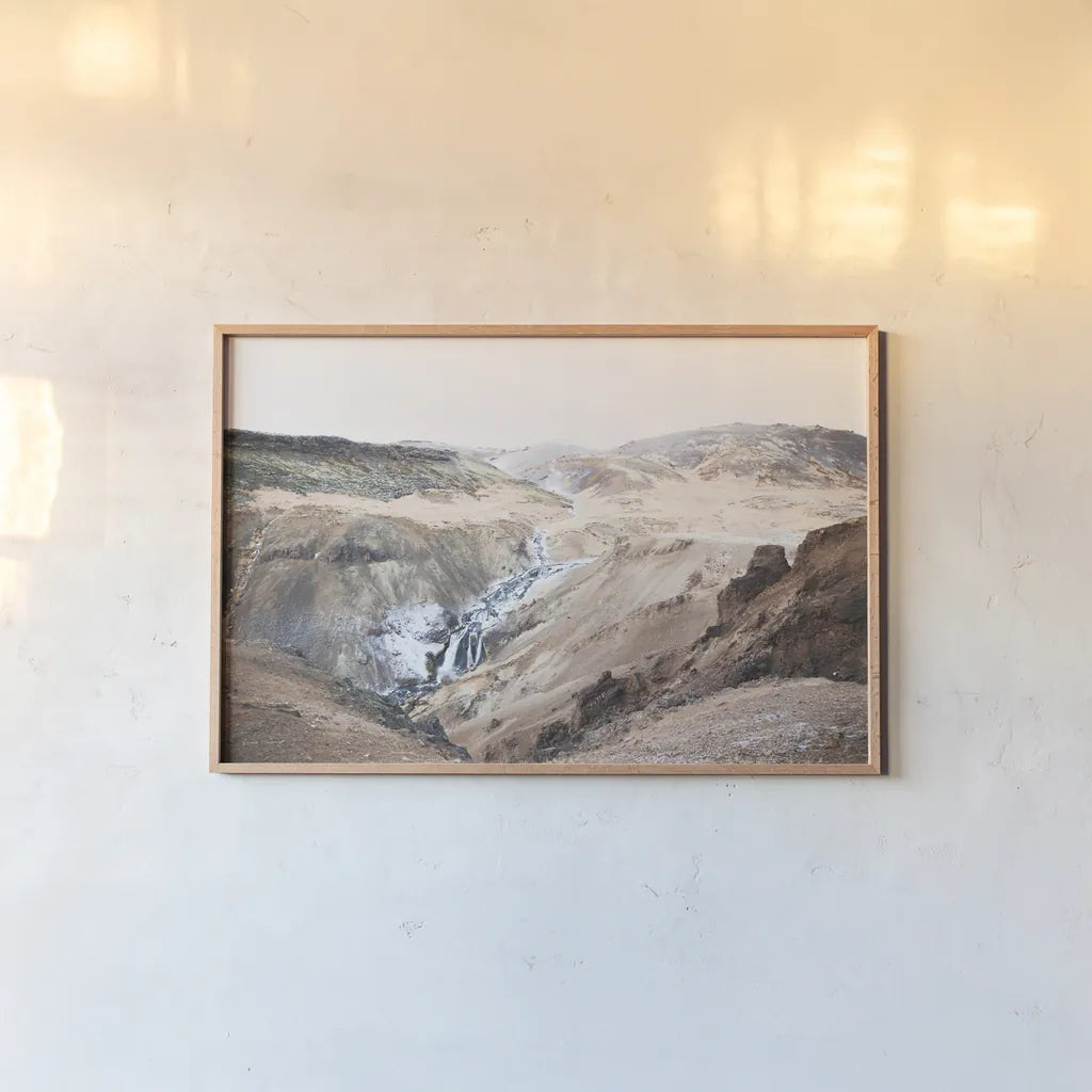 Reykjadalur Hot River by Laura Marshall. shown as a paper print in a natural frame. Available as a archival giclee rolled canvas, fine art paper, or poster print. SKU 69905i.