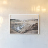 Reykjadalur Hot River by Laura Marshall. shown as a paper print in a white frame. Available as a archival giclee rolled canvas, fine art paper, or poster print. SKU 69905i.