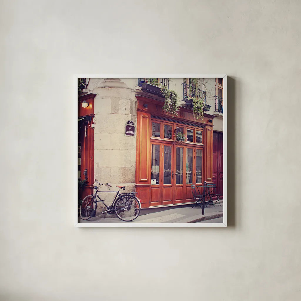 Rue Chanoinesse by Laura Marshall. Shown in a crisp white glass frame for a clean and minimalist style. Available as an archival giclee rolled canvas, fine art paper, or poster print. SKU 21920a.