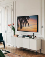 Sunset Palms I by Laura Marshall. shown as a framed stretched canvas in a living room above a console. Available as a archival giclee rolled canvas, fine art paper, or poster print. SKU 42851i.