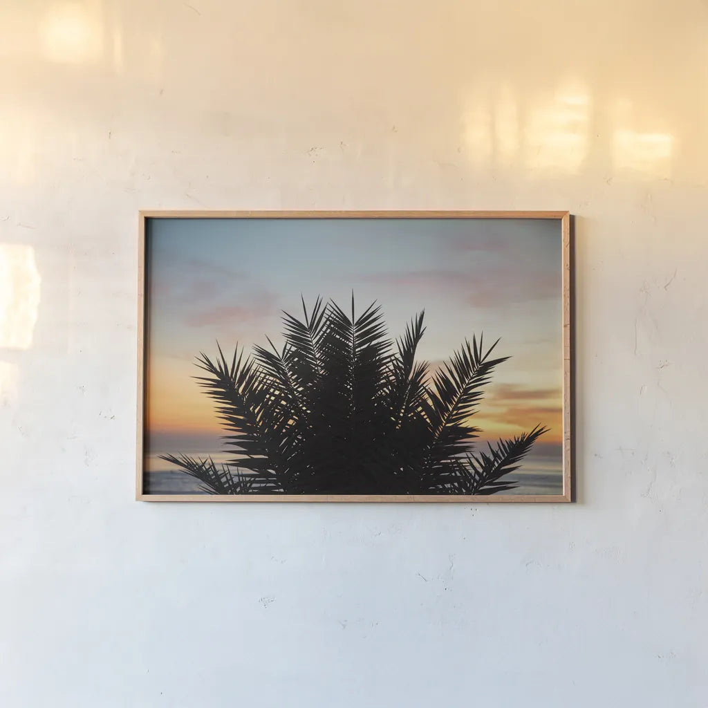 Sunset Palms II by Laura Marshall. shown as a paper print in a natural frame. Available as a archival giclee rolled canvas, fine art paper, or poster print. SKU 42852i.