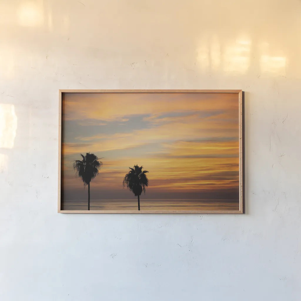 Sunset Palms III by Laura Marshall. shown as a paper print in a natural frame. Available as a archival giclee rolled canvas, fine art paper, or poster print. SKU 42853i.
