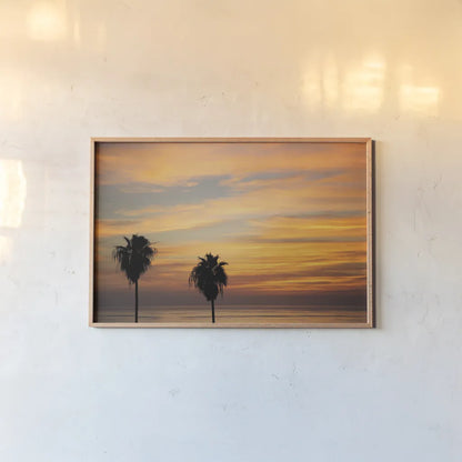 Sunset Palms III by Laura Marshall. shown as a paper print in a natural frame. Available as a archival giclee rolled canvas, fine art paper, or poster print. SKU 42853i.
