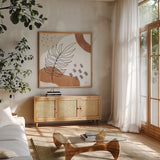 Terracotta Tropics III by Laura Marshall. Shown in a natural wood frame in a cozy modern living room. Available as an archival giclee rolled canvas, fine art paper, or poster print. SKU 56532a.