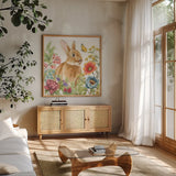 Garden Bunnies V by Leslie Trimbach. Shown in a natural wood frame in a cozy modern living room. Available as an archival giclee rolled canvas, fine art paper, or poster print. SKU 83605a.
