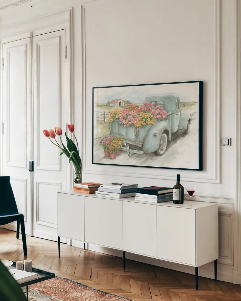 Truck with Flowers by Leslie Trimbach. shown as a framed stretched canvas in a living room above a console. Available as a archival giclee rolled canvas, fine art paper, or poster print. SKU 84630i.