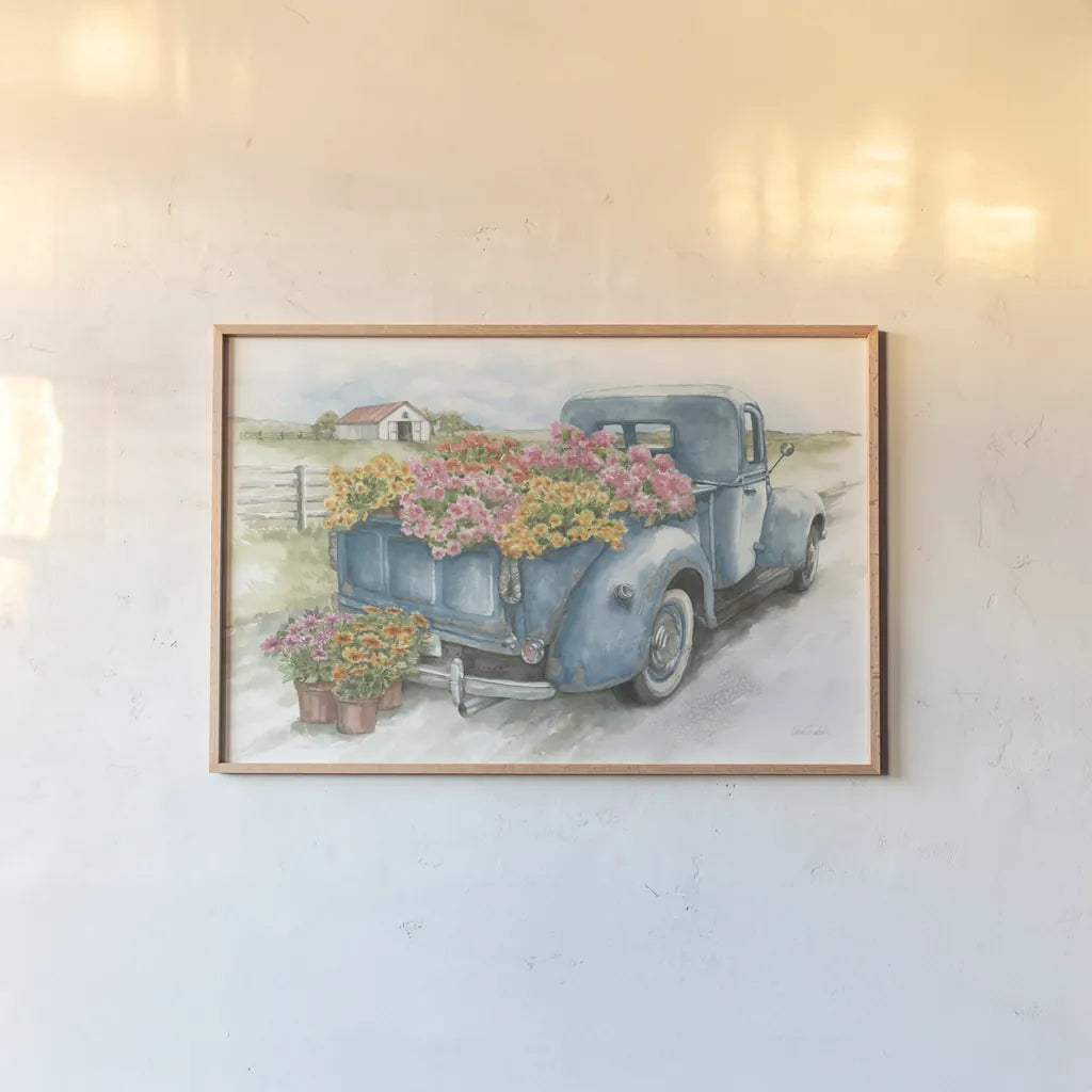 Truck with Flowers on Blue by Leslie Trimbach. shown as a paper print in a natural frame. Available as a archival giclee rolled canvas, fine art paper, or poster print. SKU 86547i.