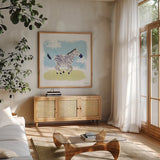 Happy Zebra by Lindley Wiesner. Shown in a natural wood frame in a cozy modern living room. Available as an archival giclee rolled canvas, fine art paper, or poster print. SKU 98372a.