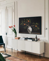 Orange Branches Still Life by Mackenzie Nelson. shown as a framed stretched canvas in a living room above a console. Available as a archival giclee rolled canvas, fine art paper, or poster print. SKU 102208i.