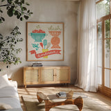 A Dash of Kindness by Mary Urban. Shown in a natural wood frame in a cozy modern living room. Available as an archival giclee rolled canvas, fine art paper, or poster print. SKU 25575a.
