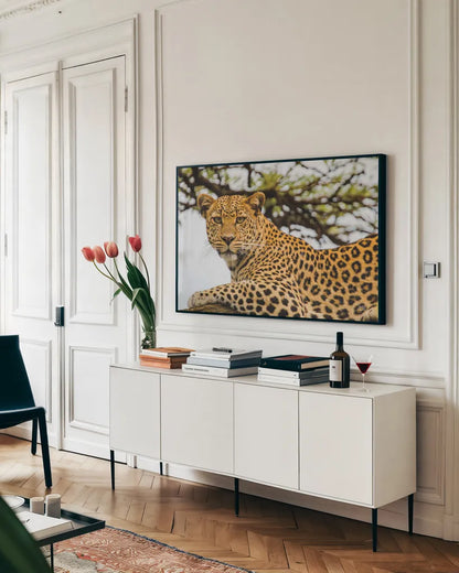 Lounging Leopard by Max Blakesberg. shown as a framed stretched canvas in a living room above a console. Available as a archival giclee rolled canvas, fine art paper, or poster print. SKU 94181i.