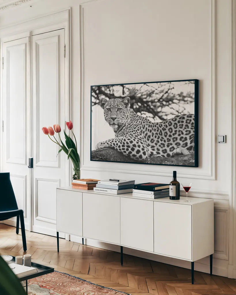 Lounging Leopard Neutral by Max Blakesberg. shown as a framed stretched canvas in a living room above a console. Available as a archival giclee rolled canvas, fine art paper, or poster print. SKU 94182i.