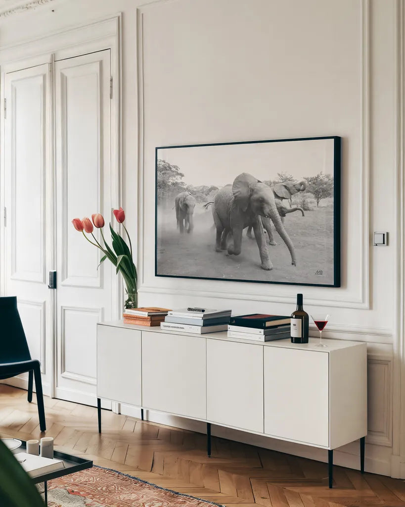 Elephant Race BW by Max Blakesberg Studios. shown as a framed stretched canvas in a living room above a console. Available as a archival giclee rolled canvas, fine art paper, or poster print. SKU 93615i.