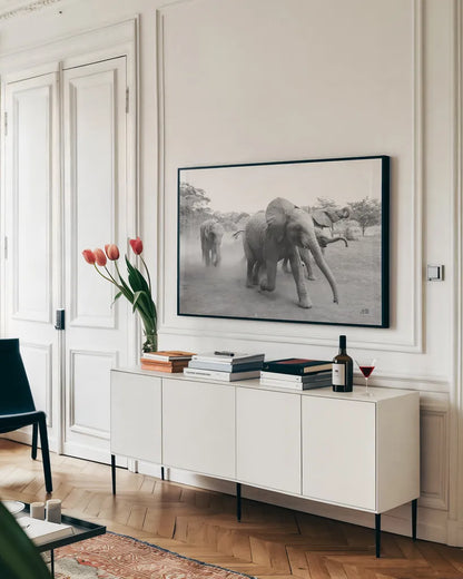 Elephant Race BW by Max Blakesberg Studios. shown as a framed stretched canvas in a living room above a console. Available as a archival giclee rolled canvas, fine art paper, or poster print. SKU 93615i.