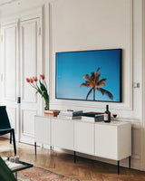 Evening Palm by Max Blakesberg Studios. shown as a framed stretched canvas in a living room above a console. Available as a archival giclee rolled canvas, fine art paper, or poster print. SKU 103354i.
