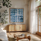 Kanari Square II Indigo by Melissa Averinos. Shown in a natural wood frame in a cozy modern living room. Available as an archival giclee rolled canvas, fine art paper, or poster print. SKU 43112a.