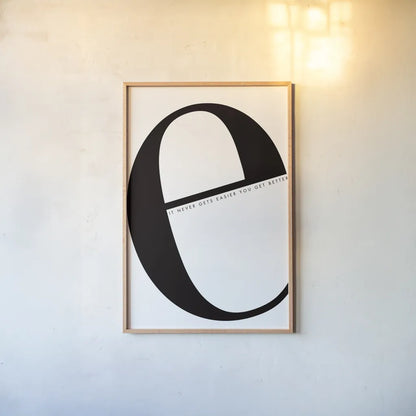E is for Easier on White by Mercedes Lopez Charro. shown as a paper print in a natural frame. Available as a archival giclee rolled canvas, fine art paper, or poster print. SKU 64145h.