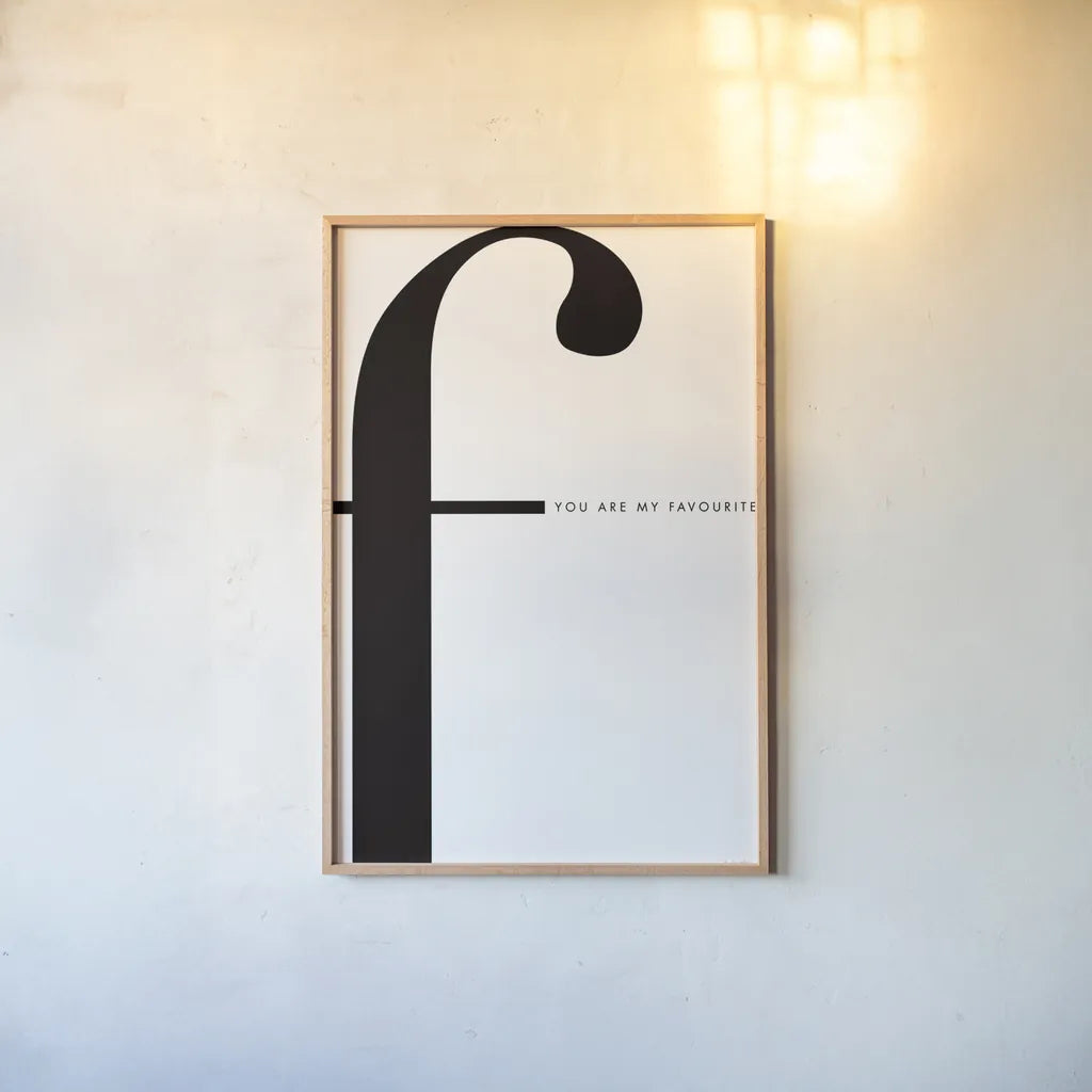 F is for favorite on White by Mercedes Lopez Charro. shown as a paper print in a natural frame. Available as a archival giclee rolled canvas, fine art paper, or poster print. SKU 64146h.