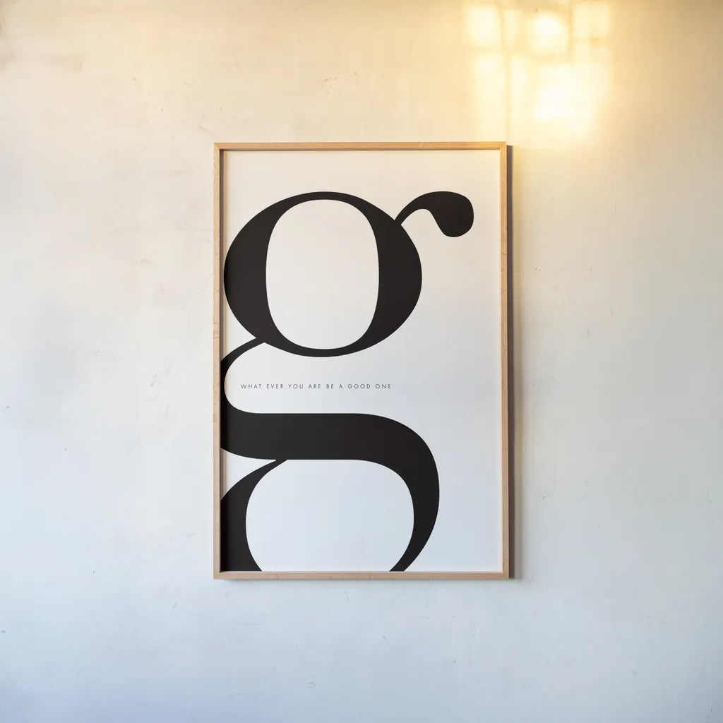 G is for Good on White by Mercedes Lopez Charro. shown as a paper print in a natural frame. Available as a archival giclee rolled canvas, fine art paper, or poster print. SKU 64147h.