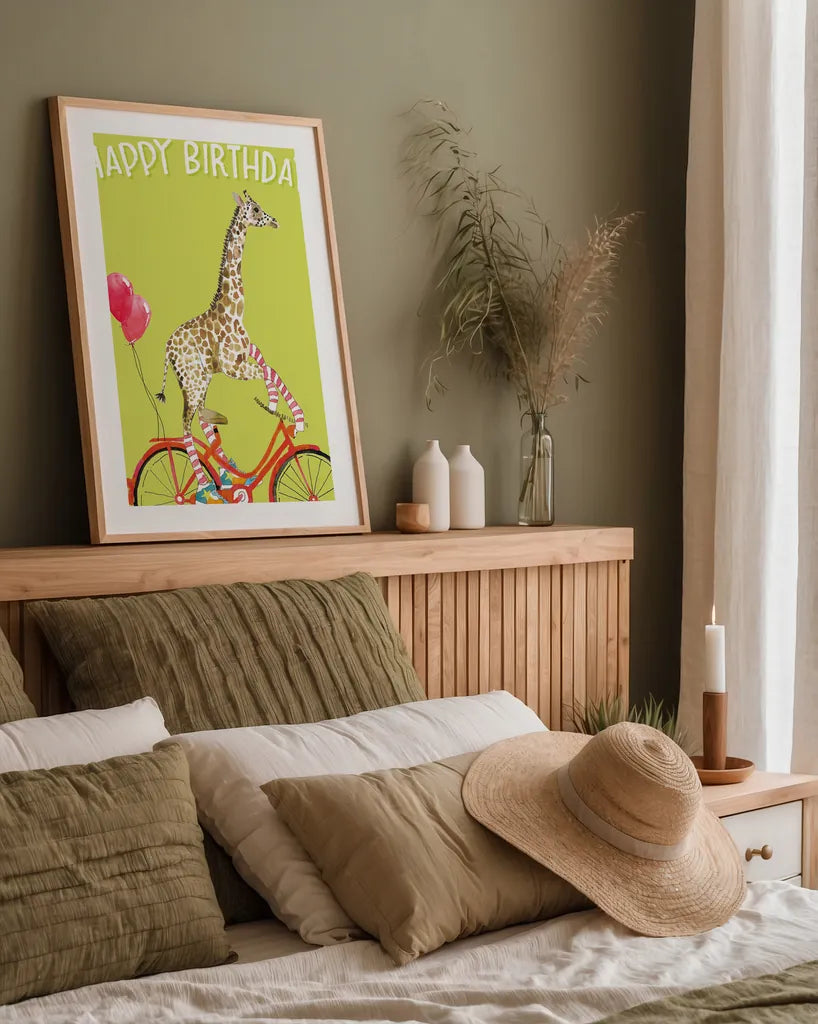 Giraffe Joy Ride I Birthday by Mercedes Lopez Charro. shown as a paper print in a natural frame. Available as a archival giclee rolled canvas, fine art paper, or poster print. SKU 78198h.
