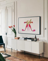 Holiday Stiletto Pair by Mercedes Lopez Charro. shown as a framed stretched canvas in a living room above a console. Available as a archival giclee rolled canvas, fine art paper, or poster print. SKU 67982i.