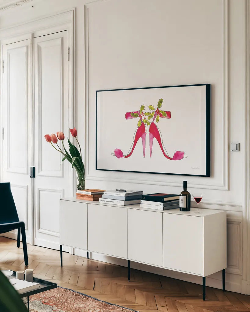 Holiday Stiletto Pair by Mercedes Lopez Charro. shown as a framed stretched canvas in a living room above a console. Available as a archival giclee rolled canvas, fine art paper, or poster print. SKU 67982i.