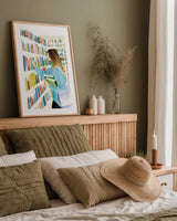 Never Enough Books II by Mercedes Lopez Charro. shown as a paper print in a natural frame. Available as a archival giclee rolled canvas, fine art paper, or poster print. SKU 98645h.