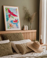 Parrots and Palms I by Mercedes Lopez Charro. shown as a paper print in a natural frame. Available as a archival giclee rolled canvas, fine art paper, or poster print. SKU 85827h.