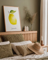 Single Lemon by Mercedes Lopez Charro. shown as a paper print in a natural frame. Available as a archival giclee rolled canvas, fine art paper, or poster print. SKU 67136h.