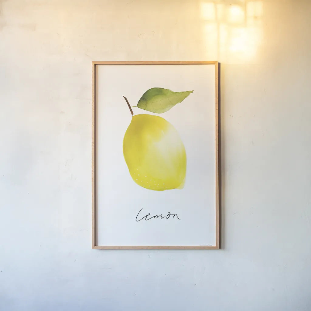 Single Lemon by Mercedes Lopez Charro. shown as a paper print in a natural frame. Available as a archival giclee rolled canvas, fine art paper, or poster print. SKU 67136h.