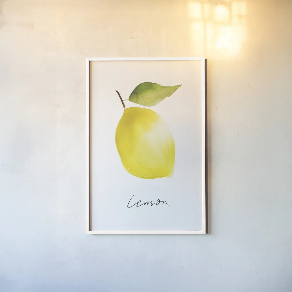 Single Lemon by Mercedes Lopez Charro. shown as a paper print in a white frame. Available as a archival giclee rolled canvas, fine art paper, or poster print. SKU 67136h.
