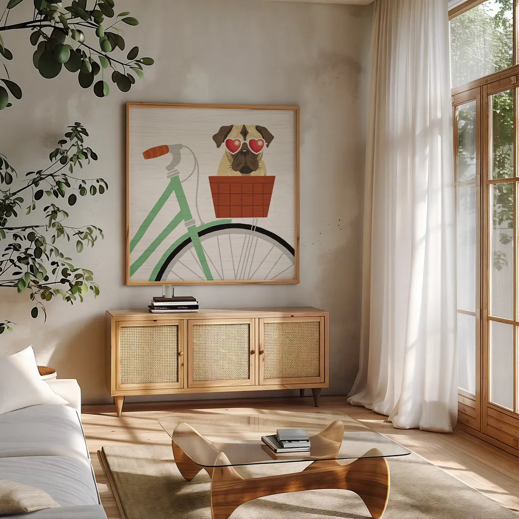Beach Bums Pug Bicycle I by Michael Mullan. Shown in a natural wood frame in a cozy modern living room. Available as an archival giclee rolled canvas, fine art paper, or poster print. SKU 23280a.