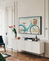 Beach Cruiser Hers I by Michael Mullan. shown as a framed stretched canvas in a living room above a console. Available as a archival giclee rolled canvas, fine art paper, or poster print. SKU 23263i.