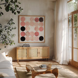 Dots II Square I Pink Black by Michael Mullan. Shown in a natural wood frame in a cozy modern living room. Available as an archival giclee rolled canvas, fine art paper, or poster print. SKU 53752a.