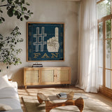 Football IV Blue by Michael Mullan. Shown in a natural wood frame in a cozy modern living room. Available as an archival giclee rolled canvas, fine art paper, or poster print. SKU 20349a.