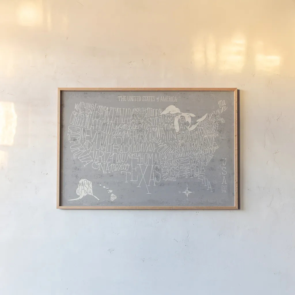 Hand Lettered USA Map Gray by Michael Mullan. shown as a paper print in a natural frame. Available as a archival giclee rolled canvas, fine art paper, or poster print. SKU 43245i.