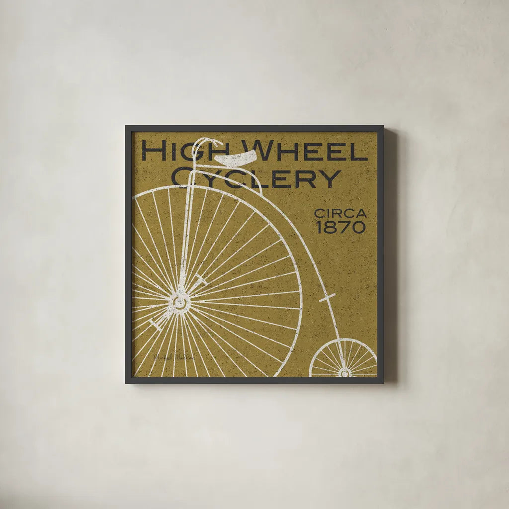 High Wheel Cyclery by Michael Mullan. Shown in a sleek black glass frame for a contemporary gallery look. Available as an archival giclee rolled canvas, fine art paper, or poster print. SKU 11869a.