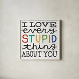I Love Every Stupid Thing About You by Michael Mullan. Shown in a crisp white glass frame for a clean and minimalist style. Available as an archival giclee rolled canvas, fine art paper, or poster print. SKU 14546a.