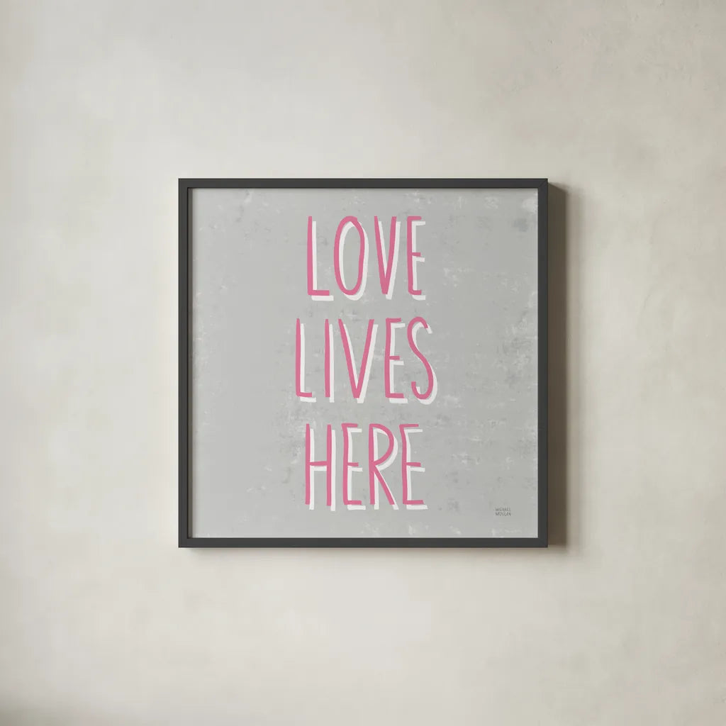 Love Lives Here Slate and Pink by Michael Mullan. Shown in a sleek black glass frame for a contemporary gallery look. Available as an archival giclee rolled canvas, fine art paper, or poster print. SKU 67444a.