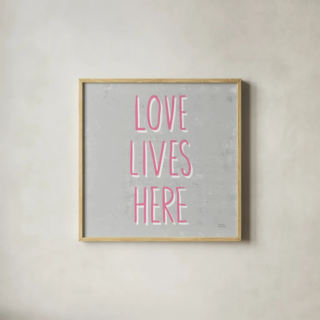 Love Lives Here Slate and Pink by Michael Mullan. Shown in a natural wood glass frame for a timeless modern aesthetic. Available as an archival giclee rolled canvas, fine art paper, or poster print. SKU 67444a.