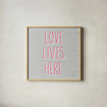 Love Lives Here Slate and Pink by Michael Mullan. Shown in a natural wood glass frame for a timeless modern aesthetic. Available as an archival giclee rolled canvas, fine art paper, or poster print. SKU 67444a.