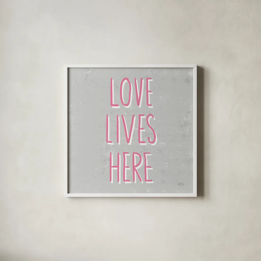 Love Lives Here Slate and Pink by Michael Mullan. Shown in a crisp white glass frame for a clean and minimalist style. Available as an archival giclee rolled canvas, fine art paper, or poster print. SKU 67444a.