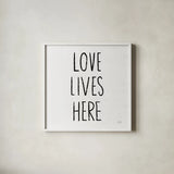 Love Lives Here Sq BW by Michael Mullan. Shown in a crisp white glass frame for a clean and minimalist style. Available as an archival giclee rolled canvas, fine art paper, or poster print. SKU 54656a.