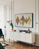 Mod Triangles II Retro by Michael Mullan. shown as a framed stretched canvas in a living room above a console. Available as a archival giclee rolled canvas, fine art paper, or poster print. SKU 22310i.