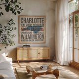 North Carolina by Michael Mullan. Shown in a natural wood frame in a cozy modern living room. Available as an archival giclee rolled canvas, fine art paper, or poster print. SKU 18071a.