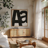 Punctuated Black Square I by Michael Mullan. Shown in a natural wood frame in a cozy modern living room. Available as an archival giclee rolled canvas, fine art paper, or poster print. SKU 50692a.