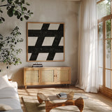 Punctuated Black Square IX by Michael Mullan. Shown in a natural wood frame in a cozy modern living room. Available as an archival giclee rolled canvas, fine art paper, or poster print. SKU 50694a.