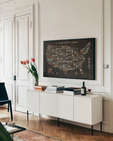 US City Map Black by Michael Mullan. shown as a framed stretched canvas in a living room above a console. Available as a archival giclee rolled canvas, fine art paper, or poster print. SKU 20462i.