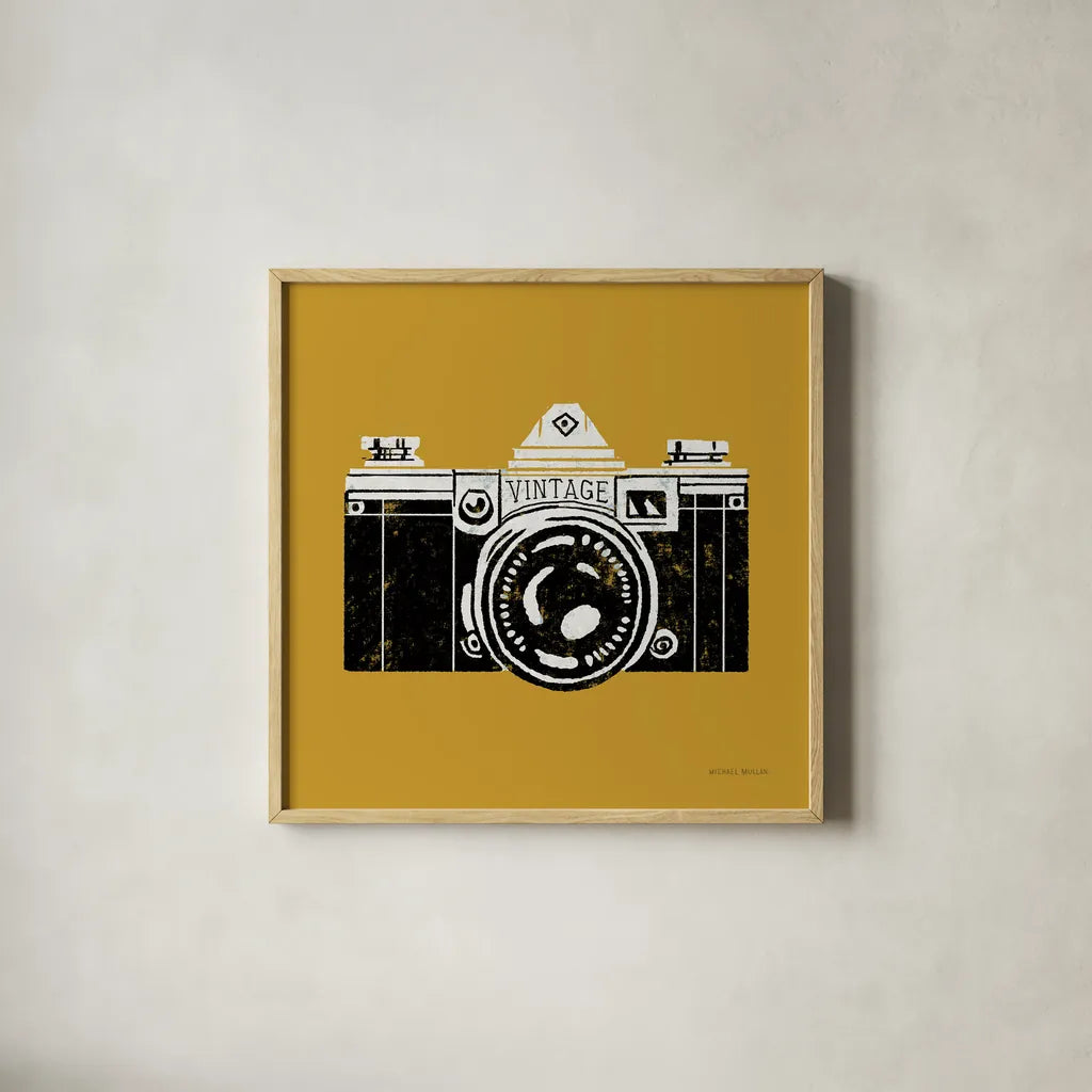 Vintage Camera Yellow by Michael Mullan. Shown in a natural wood glass frame for a timeless modern aesthetic. Available as an archival giclee rolled canvas, fine art paper, or poster print. SKU 60983a.