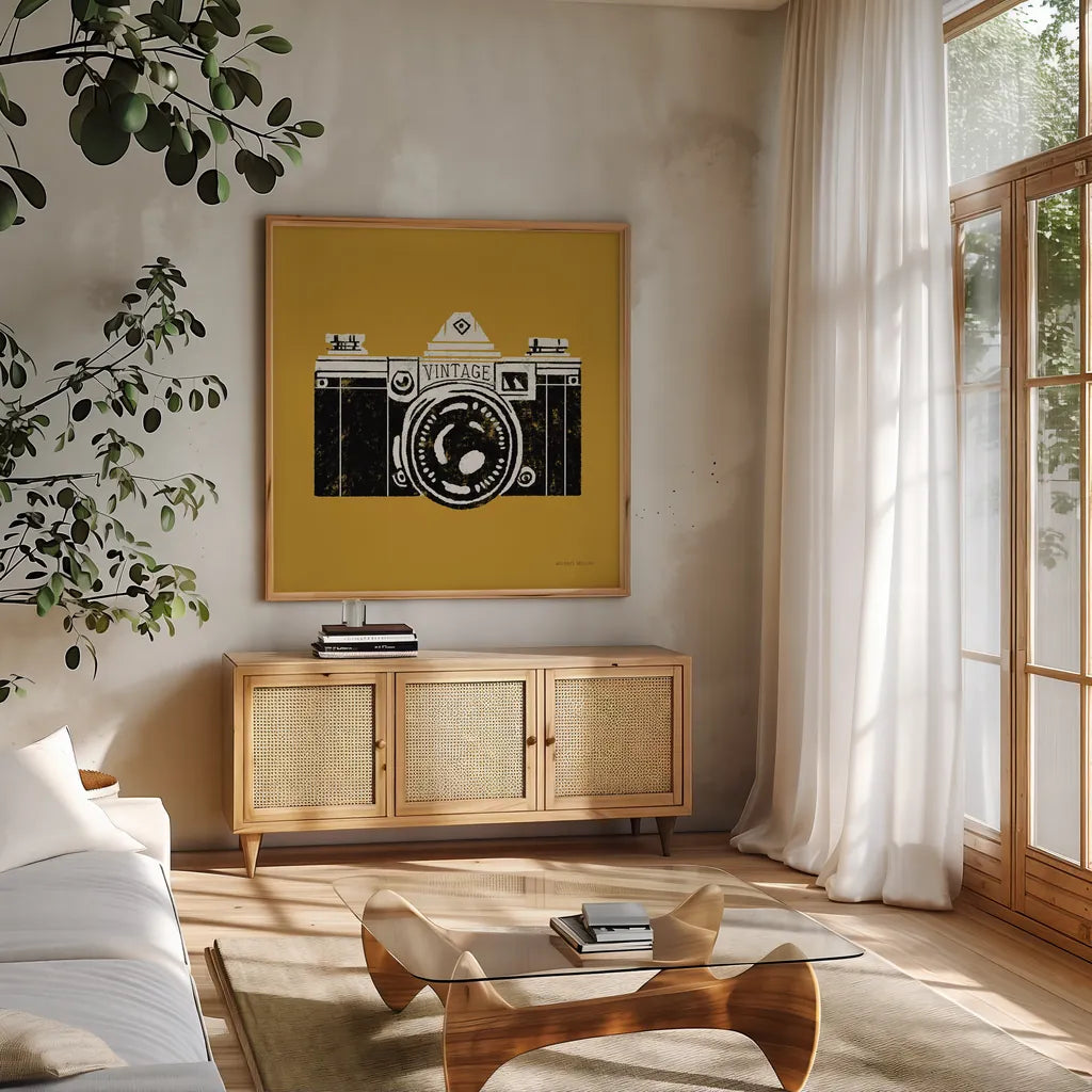 Vintage Camera Yellow by Michael Mullan. Shown in a natural wood frame in a cozy modern living room. Available as an archival giclee rolled canvas, fine art paper, or poster print. SKU 60983a.